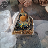 Orgonite Pyramidale de 6 cm de Côté en Résine avec des Pépites en Obsidienne Noire et 1 Boule en Œil de Tigre, du Métal et un Décor Arbre de Vie sur pierre de lave
