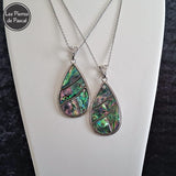 Pendentif Coquille d'Ormeau Arc en Ciel de Nouvelle Zélande Grade A en Forme de Grosse Larme et une Chaîne en Métal de 50 cm sur un buste blanc